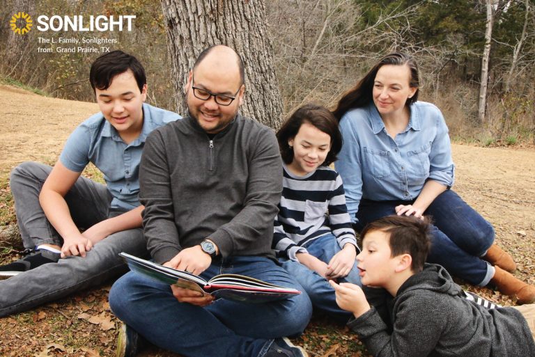 an entire family reads outside