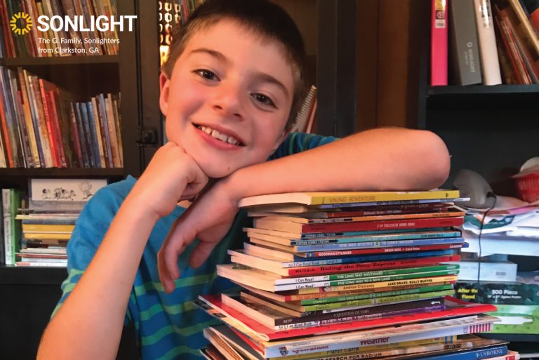 happy Sonlight student poses with his books