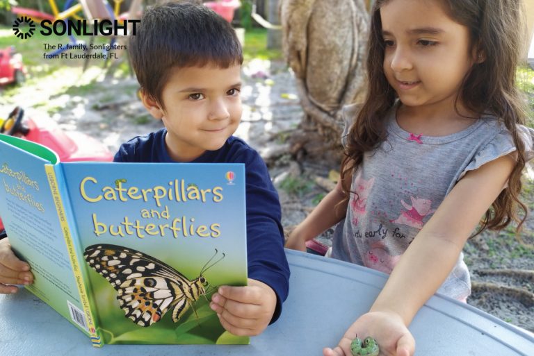 a boy holds a book about caterpillars and butterflies while his sister holds a green caterpillar