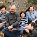 an entire family reads outside