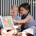 two preschoolers enjoy a book